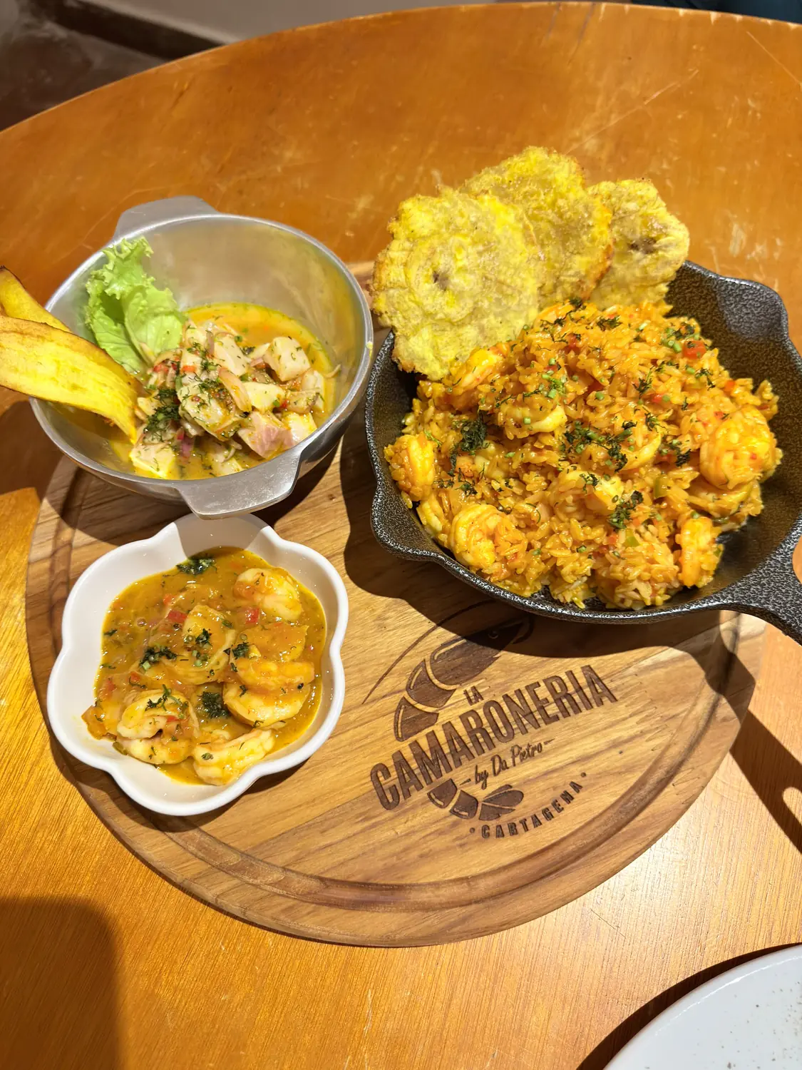 Pique XL sobre la tabla de La Camaronería: camarones en salsa, arroz a la Camaronera, ceviche de ají amarillo y patacones